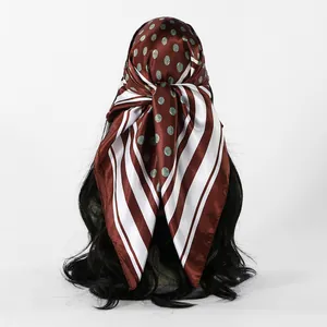 Detailweergave van een bruine satijnen vierkante sjaal met stippen en strepen als hoofddoek