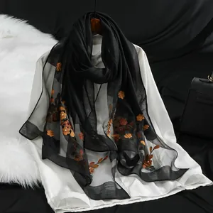 Elegante sciarpa lunga in organza nera con i raffinati ricami floreali arancioni