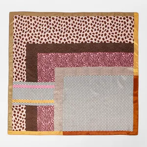 Vue à plat d'un foulard carré en satin à imprimé léopard et motifs géométriques.