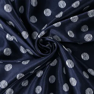 Macro-opname van marineblauwe satijnen stof met witte golf-textuur polkadot print