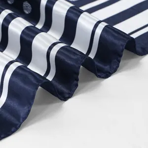 Detailopname van de gladde satijnen textuur van deze marineblauw gestreepte sjaal