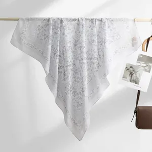Detailed view of the elegant grey floral pattern on a white Bali yarn square scarf