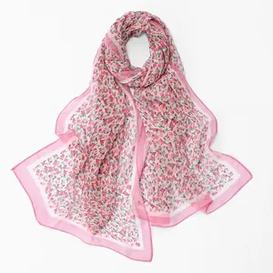Macro view of lightweight pink floral chiffon scarf showing elegant rose pattern edges