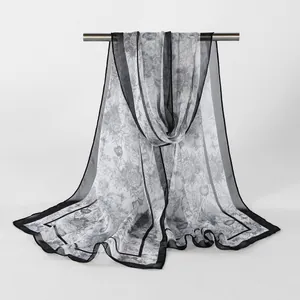 Close-up view of a lightweight floral georgette scarf with elegant black border and drape