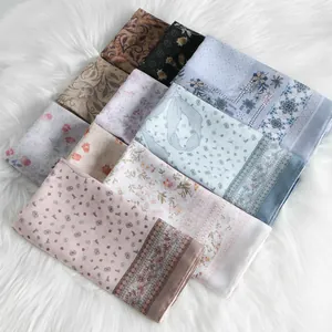 Assorted floral printed Bali yarn square scarves displayed on a soft white faux fur rug