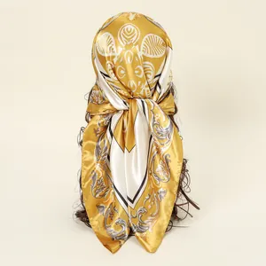 Detailansicht eines gold-weißen Satin-Kopftuchs mit Print auf einem Styling-Haar-Prop