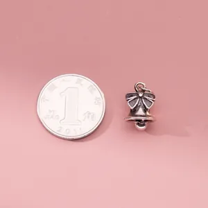 Oxidized S925 silver bowknot bell pendant for DIY jewelry on pink background