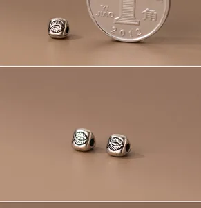 Primo piano di perle triangolari in argento 925 con motivo a lisca di pesce ossidato.