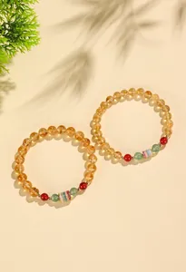 Detailansicht von gelben Zitrinperlen-Armbändern mit bunter Sutra-Röhre.