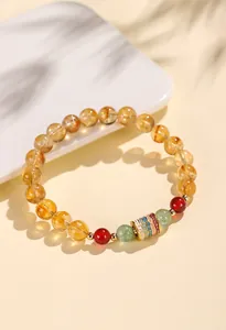 Detailansicht eines Armbands aus Citrin und Achat mit einem tibetischen Mantra-Anhänger