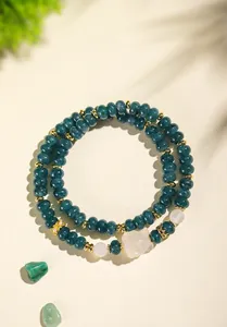 Detail view of a double-strand green chalcedony beaded bracelet with fox charm