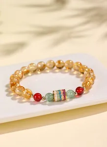 Detail eines chinesischen Armbands mit gelbem Quarz, rotem Achat und Schriftperle.