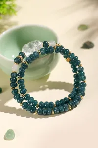 Macro view of double-strand dark green chalcedony beaded bracelet with a carved fox charm