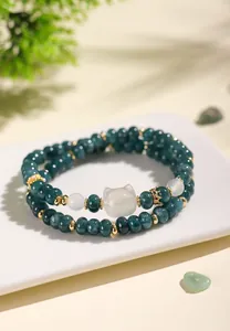 Detailed view of double-layered chalcedony bracelet with teal beads and cat-shaped charm.
