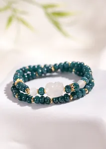 Close-up detail of dark green agate beaded double-loop bracelet with white fox charm