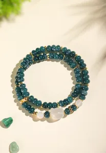 Detailed macro view of dark green chalcedony double-strand bracelet with cat bead