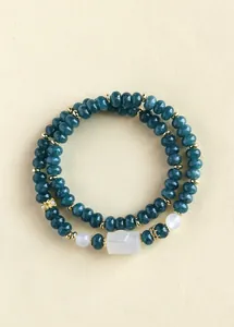 Detailed macro view of dark green chalcedony double-strand bracelet with central white jade