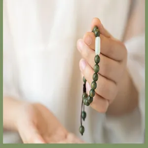 Gros plan détaillé d'un bracelet en bois de santal vert avec une perle de jade