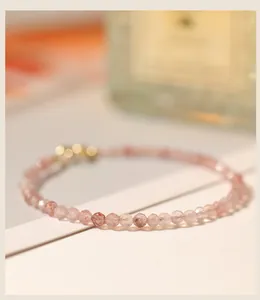 Detailansicht von 3mm facettierten Erdbeerquarz-Perlen auf einem rosa Kristallarmband.