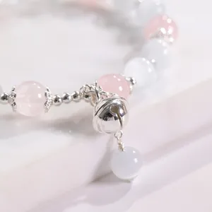 Pulsera hecha a mano de cuarzo rosa y piedra ojo de gato con un delicado colgante de cascabel de plata