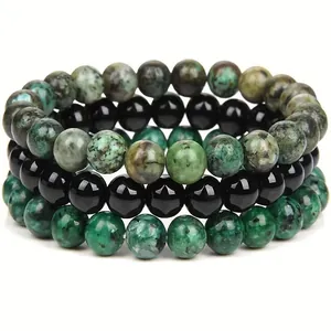 Close-up view of a three-piece natural stone bracelet set with turquoise and black beads