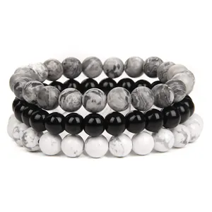Close-up detail of stackable natural stone beaded bracelets in grey, black, and white marble.