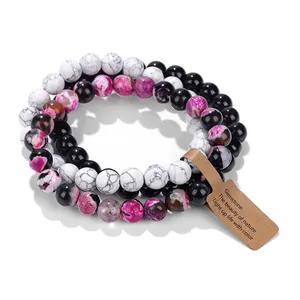 Macro view of three natural stone beaded bracelets featuring a brown gemstone kraft tag