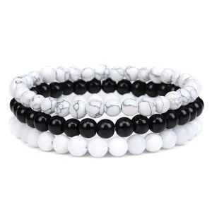 Stacked set of three natural stone beaded bracelets in black and white tones for unisex.