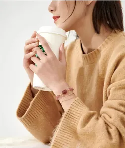 Primer plano de pulsera Pixiu de cuarzo fresa natural y brazalete de oro en la muñeca