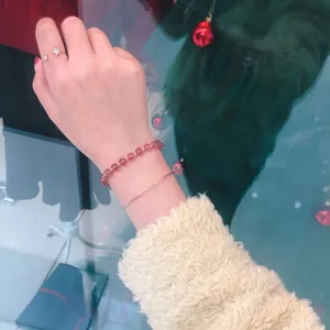 Detail showing natural strawberry quartz crystal bracelet on wrist with gold jewelry