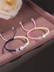 Détail du trèfle à quatre feuilles en argent 925 et agate blanche sur bracelet tissé main