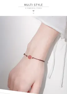 Detailed close-up view of a strawberry crystal bracelet on a delicate female wrist