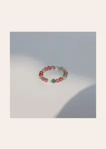 Detailed view of a 3mm mini natural rainbow tourmaline beaded ring on white surface.