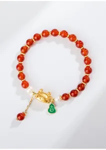 Rode agaat kralenarmband met gouden draak bedeltje en gelukkige groene kalebas hanger.