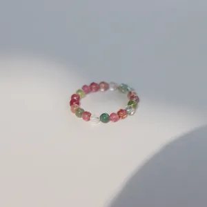 Minimalist 3mm natural rainbow tourmaline beaded ring for stacking, soft sunlight view.