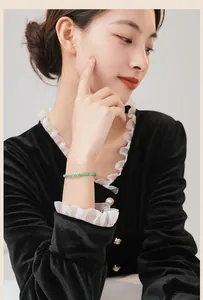 Modell trägt ein feines 3mm facettiertes grünes Aventurin-Steinperlenarmband im Retro-Stil.