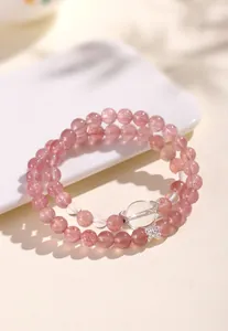 Close-up detail of strawberry quartz and clear quartz double-loop beaded bracelet for women