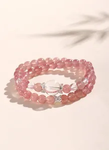 Macro detail of double-layer strawberry and clear quartz beaded bracelet with silver spacers