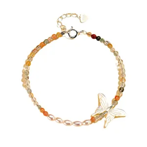 Elegant handmade crystal and pearl bracelet featuring a delicate white shell butterfly charm.
