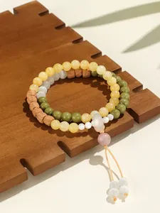 Detalle macro de una pulsera de doble hilera con cuentas amarillas y verdes