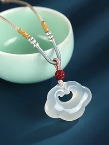 Detailed macro view of white agate Ruyi lock pendant with silver beads on woven necklace cord