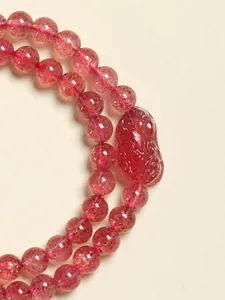 Détail de perles de cristal de fraise naturel avec breloque sculptée pour bijou femme