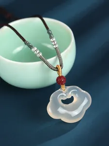 Detailed close-up of a translucent white agate Ruyi lock pendant on braided cord