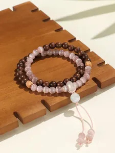 Detalle de las cuentas de ojo de gato rosa y la textura de madera en una pulsera doble