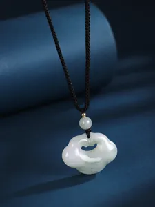 Close-up of white jade Ruyi lock pendant with black cord necklace in Chinese style.