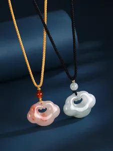 Detailed view of Ruyi cloud jade pendants with braided cords in red and white stones