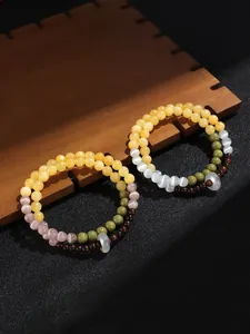 Detalle de pulsera de cuentas de doble vuelta con ojo de gato y madera de sándalo.