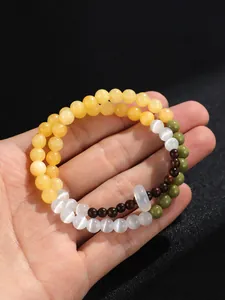 Primer plano detallado que muestra cuentas de ojo de gato y sándalo en la pulsera doble
