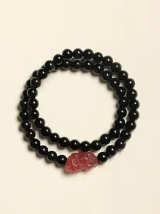 Vue détaillée d'un bracelet double rang avec perles noires et quartz rouge gravé