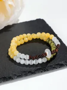 Primer plano detallado de una pulsera de doble capa con cuentas de ojo de gato y sándalo